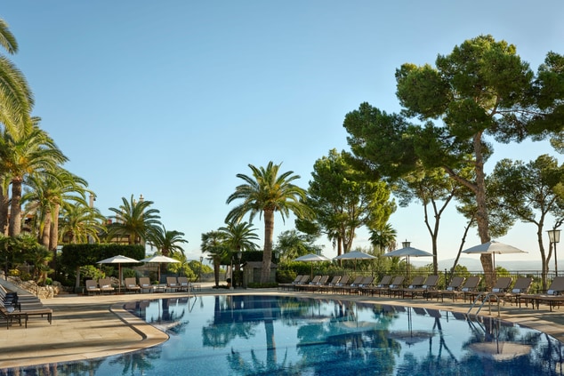 The swimming pool, trees, sunbeds and views.