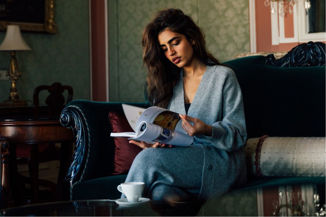 woman sitting, reading magazine