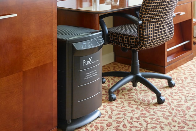Pure Room with air filter by a desk and chair.