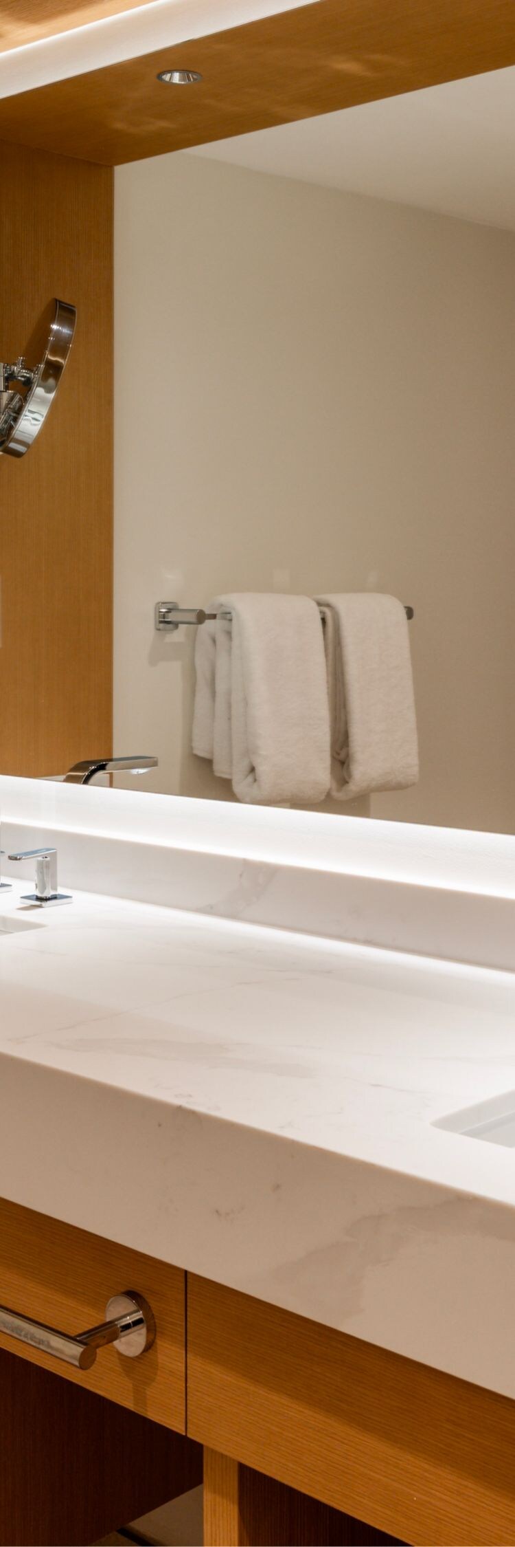 A well-lit bathroom featuring double sinks, a larg