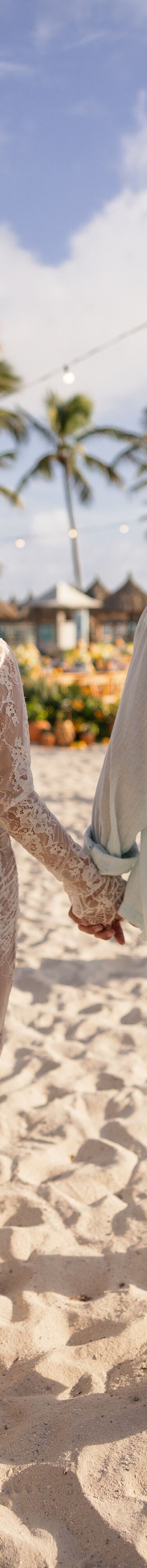 Couple walking hand in hand on beach resort ground