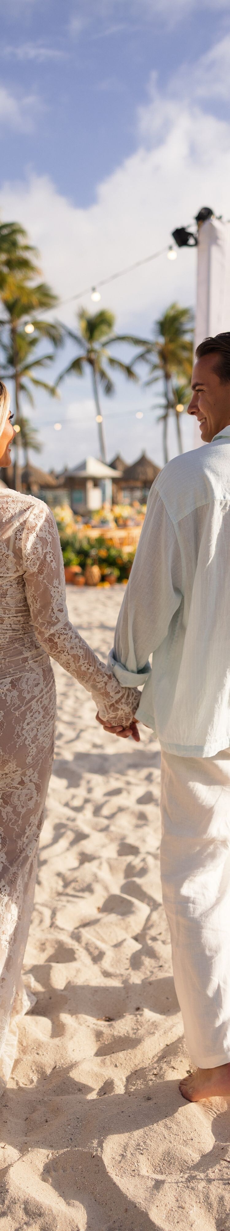 Couple walking hand in hand on beach resort ground