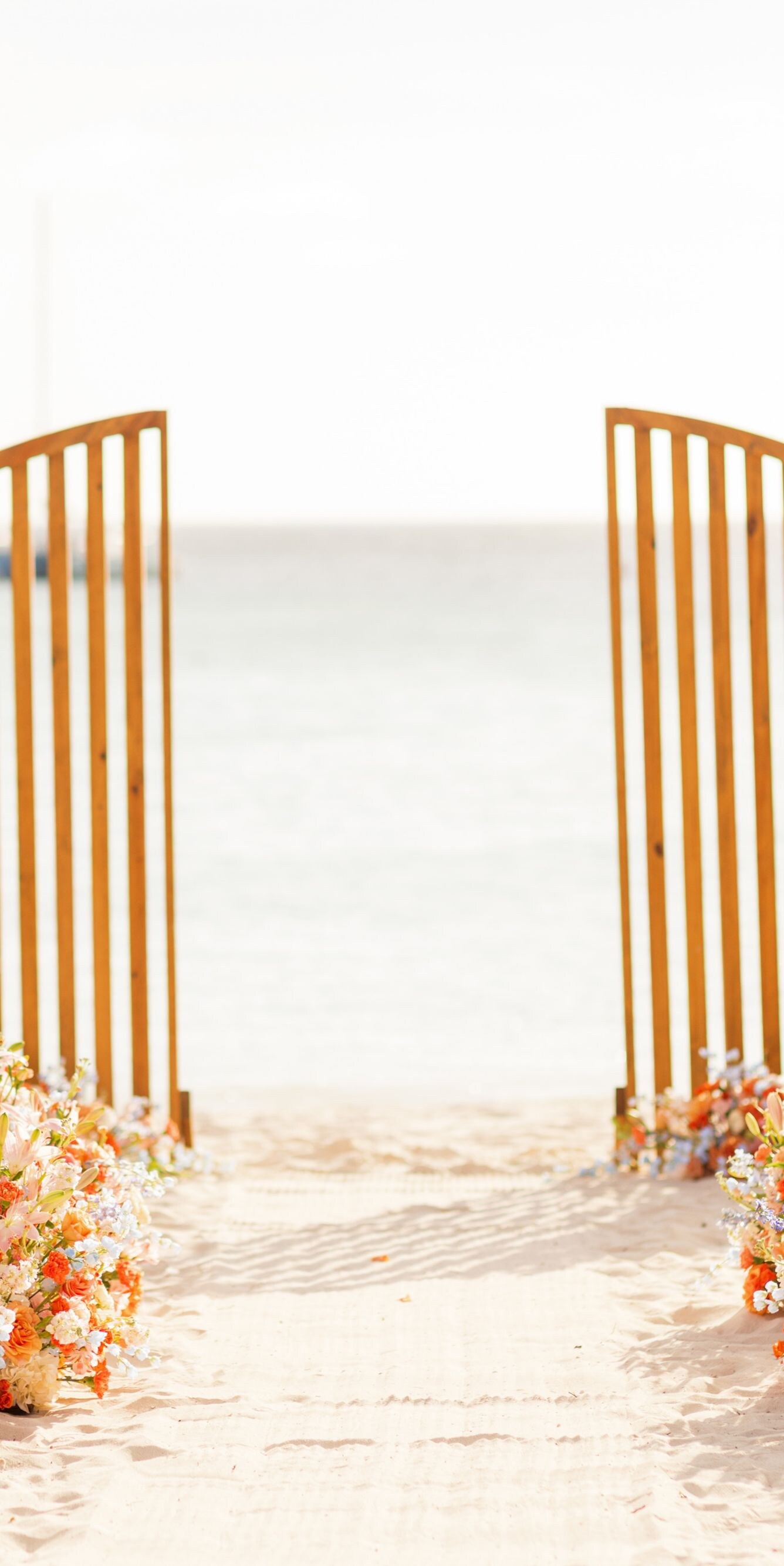 Beachfront wedding ceremony setup on white sand 