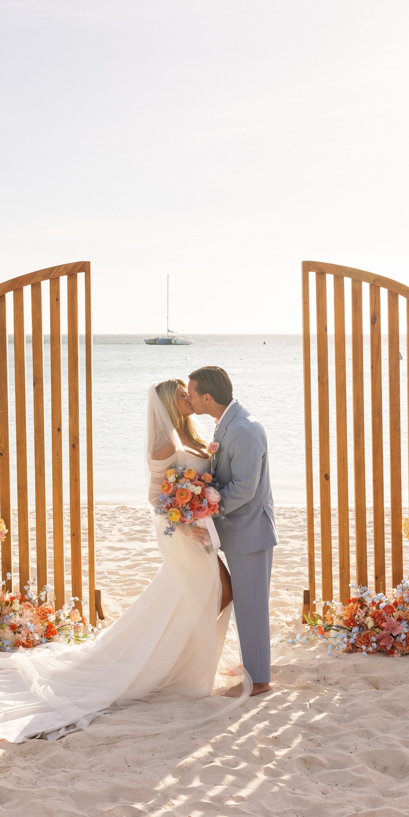 Beachfront wedding ceremony on white sand featurin