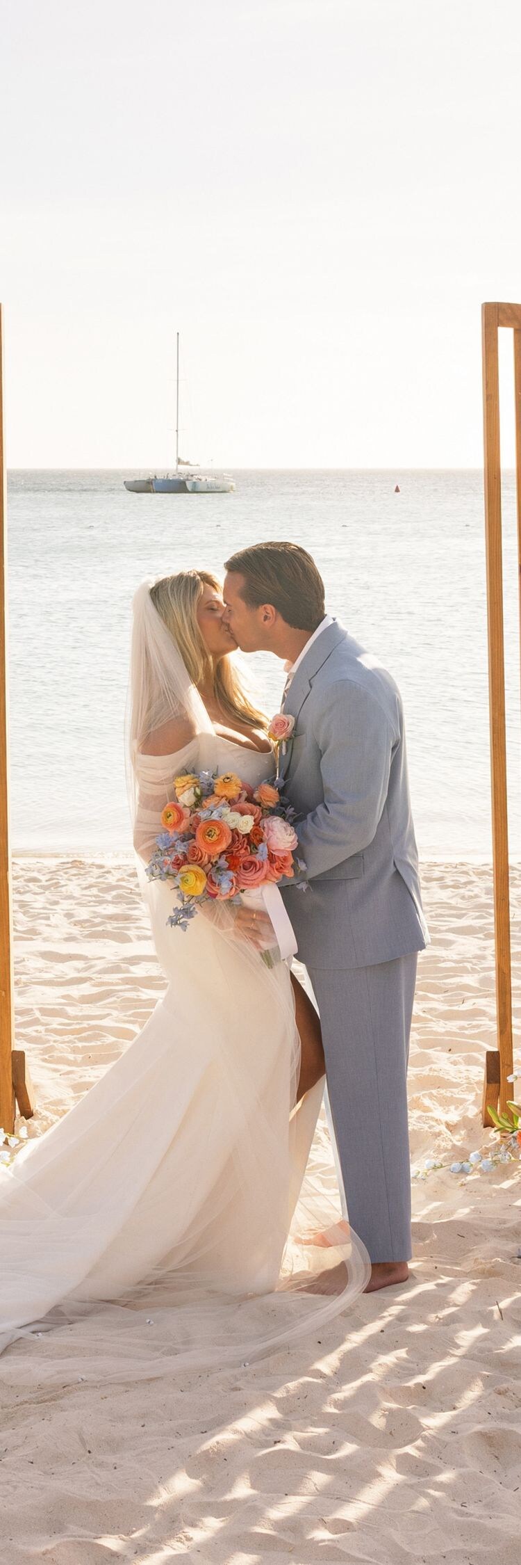 Beachfront wedding ceremony on white sand featurin