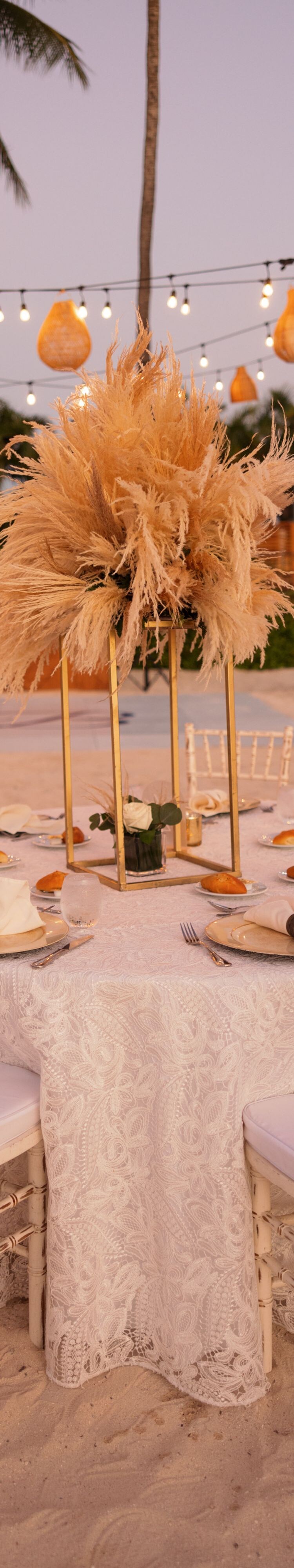 Round reception table set on a sandy beach 