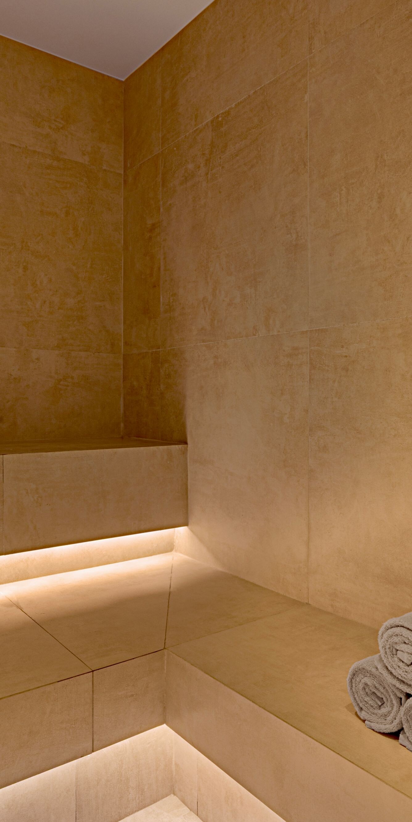 Steam room with stone bench and towels