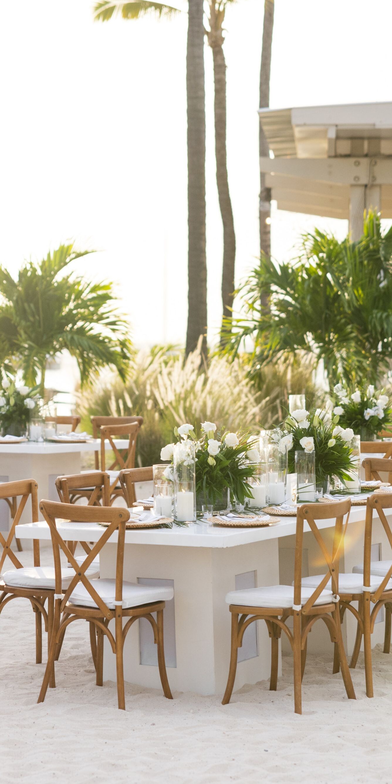 Outdoor wedding reception setup on a sandy beach