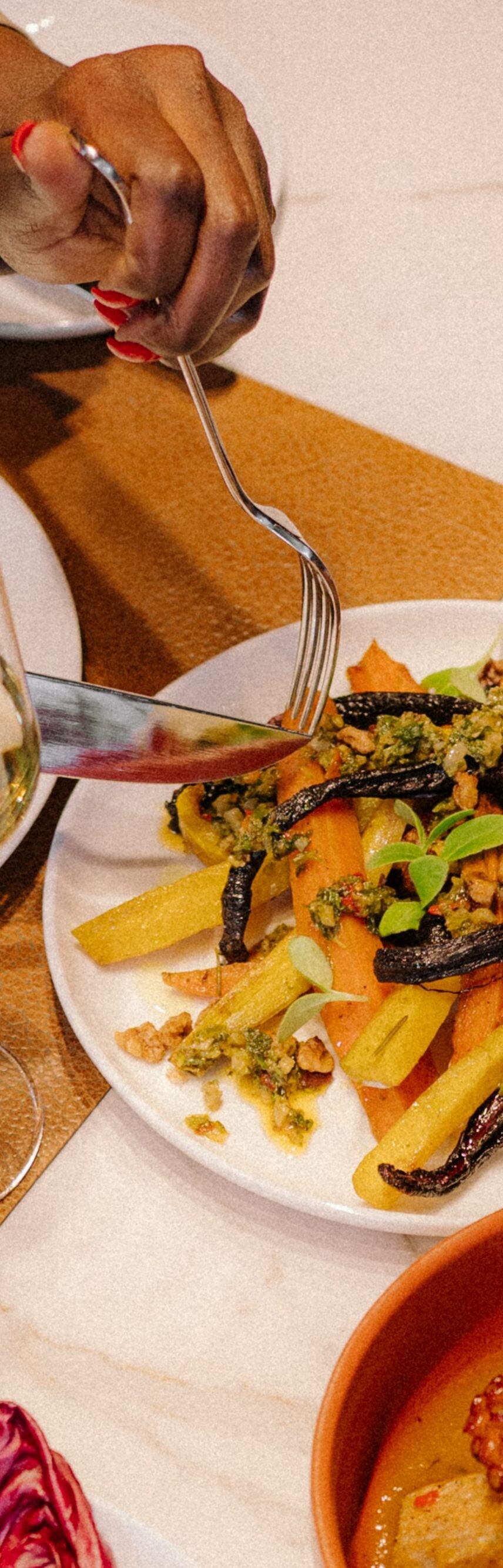 four dishes on a table with red wine
