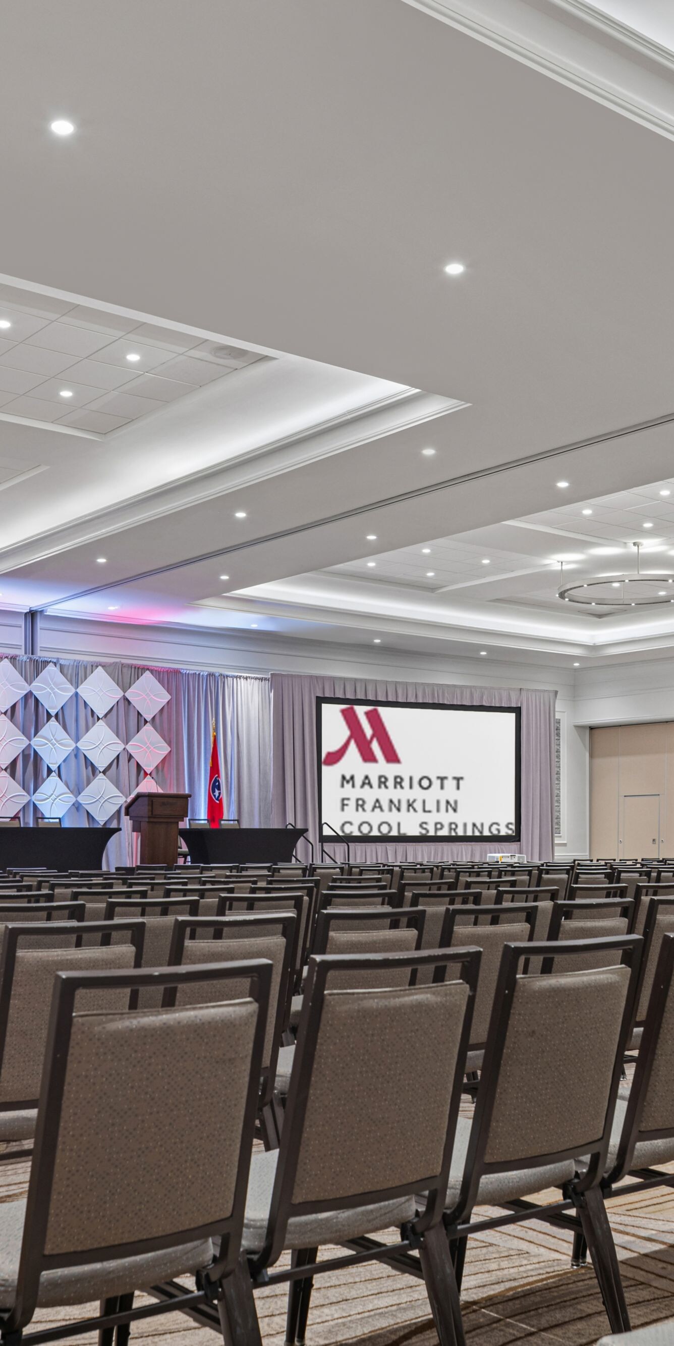 ballroom with rows of chairs and two screens