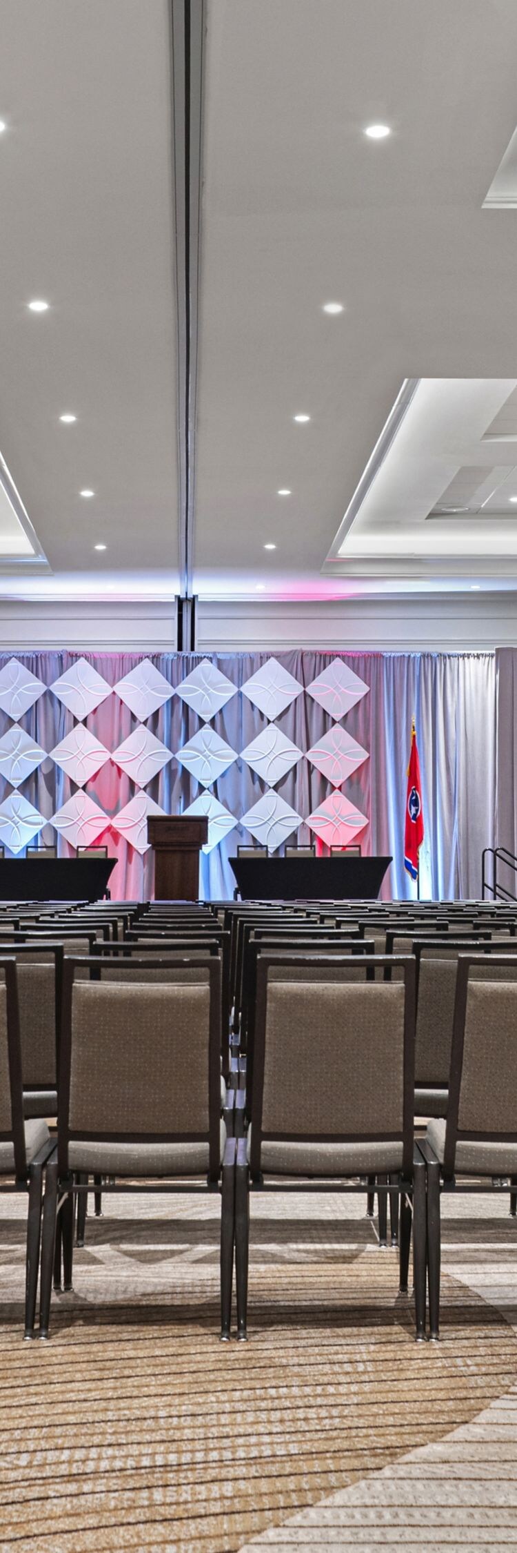 meeting room with rows of chairs and two screens