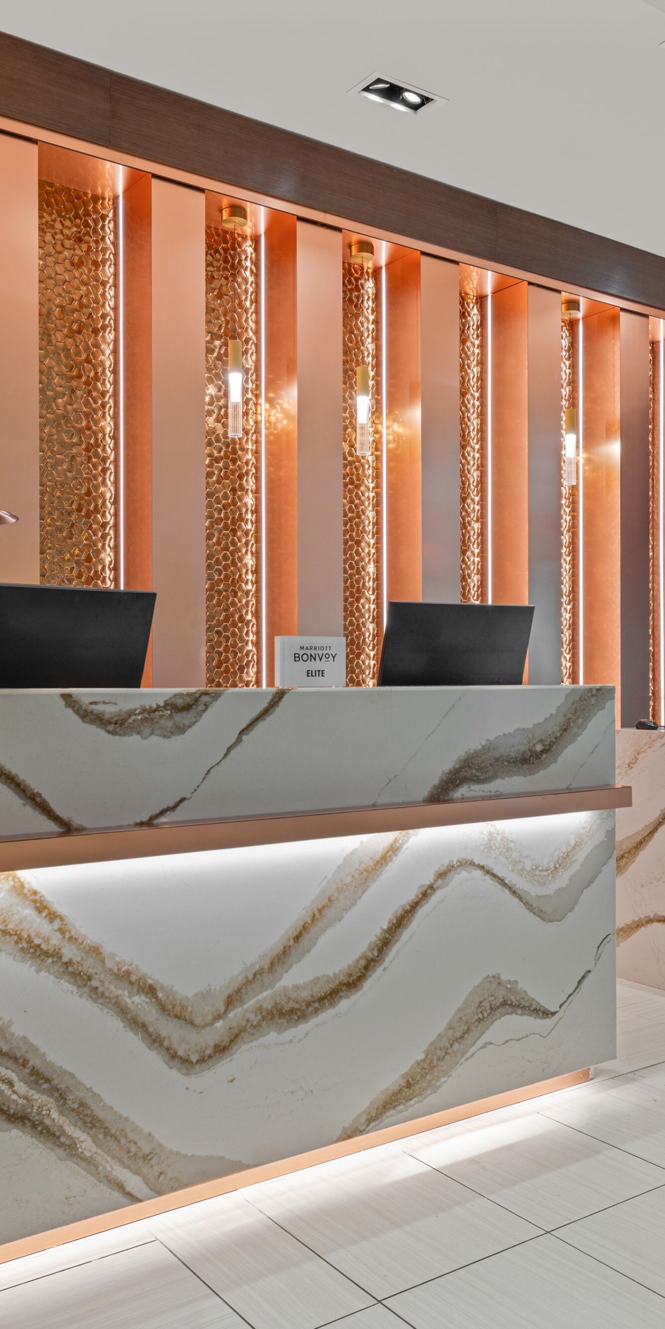 two white & gold desks in front of a backlit wall