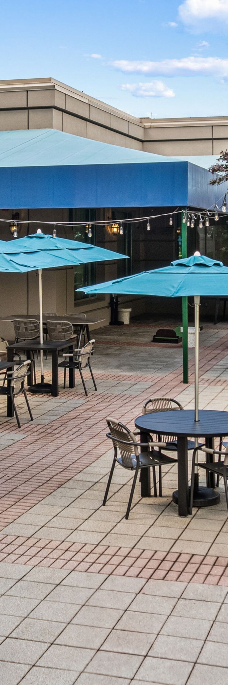 tables with umbrellas and chairs on patio