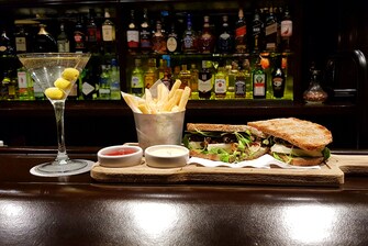 Copa de martini y sándwich con patatas fritas.