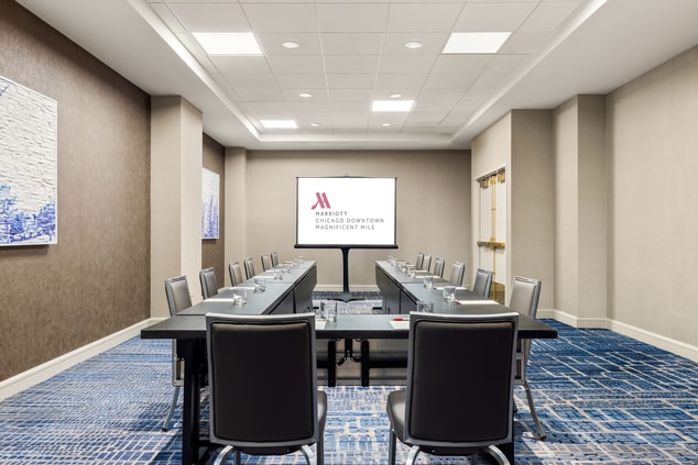 meeting room set in a u-shape with a screen in fro