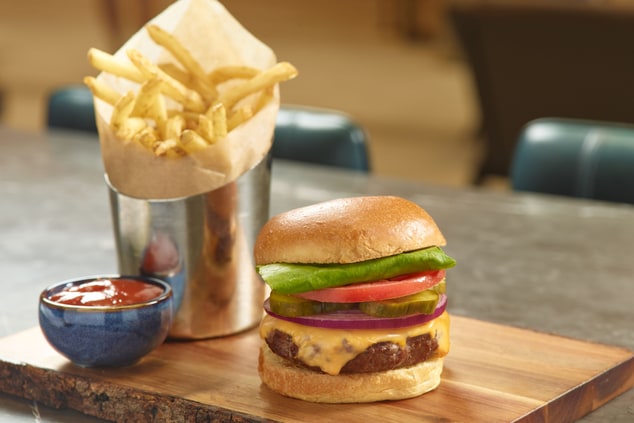 cheeseburger served with a tin of French fries