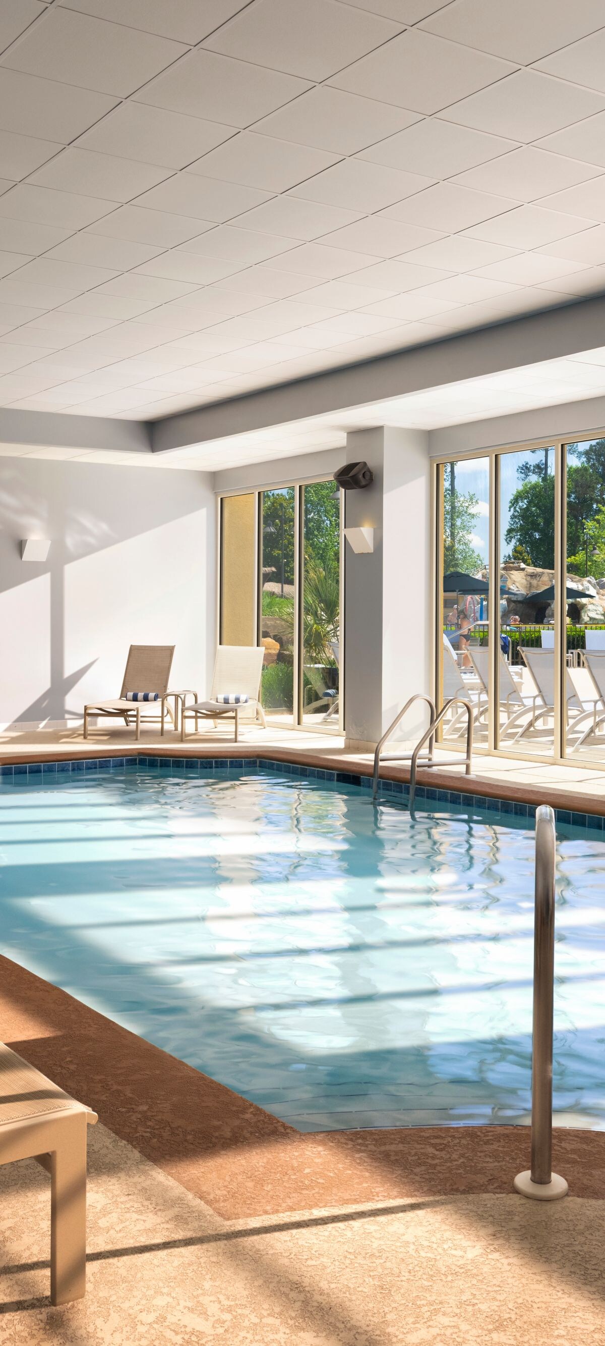 Indoor pool with lounge chairs and hot tub