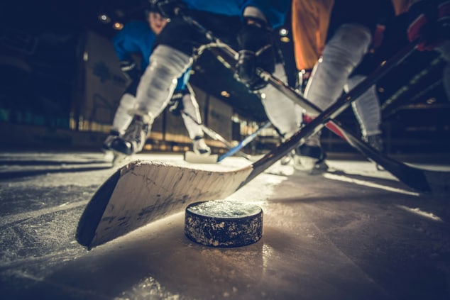 hockey sticks and puck on ice