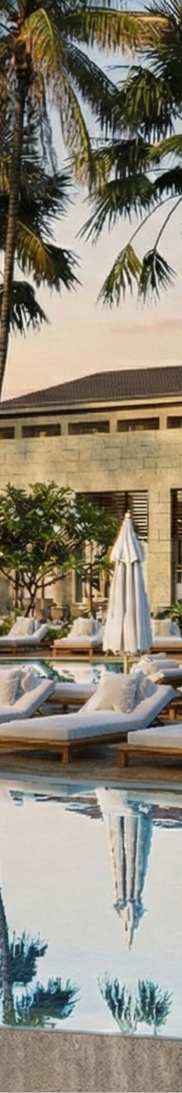 Hồ bơi của khu nghỉ dưỡng với ghế nằm và cây cọ