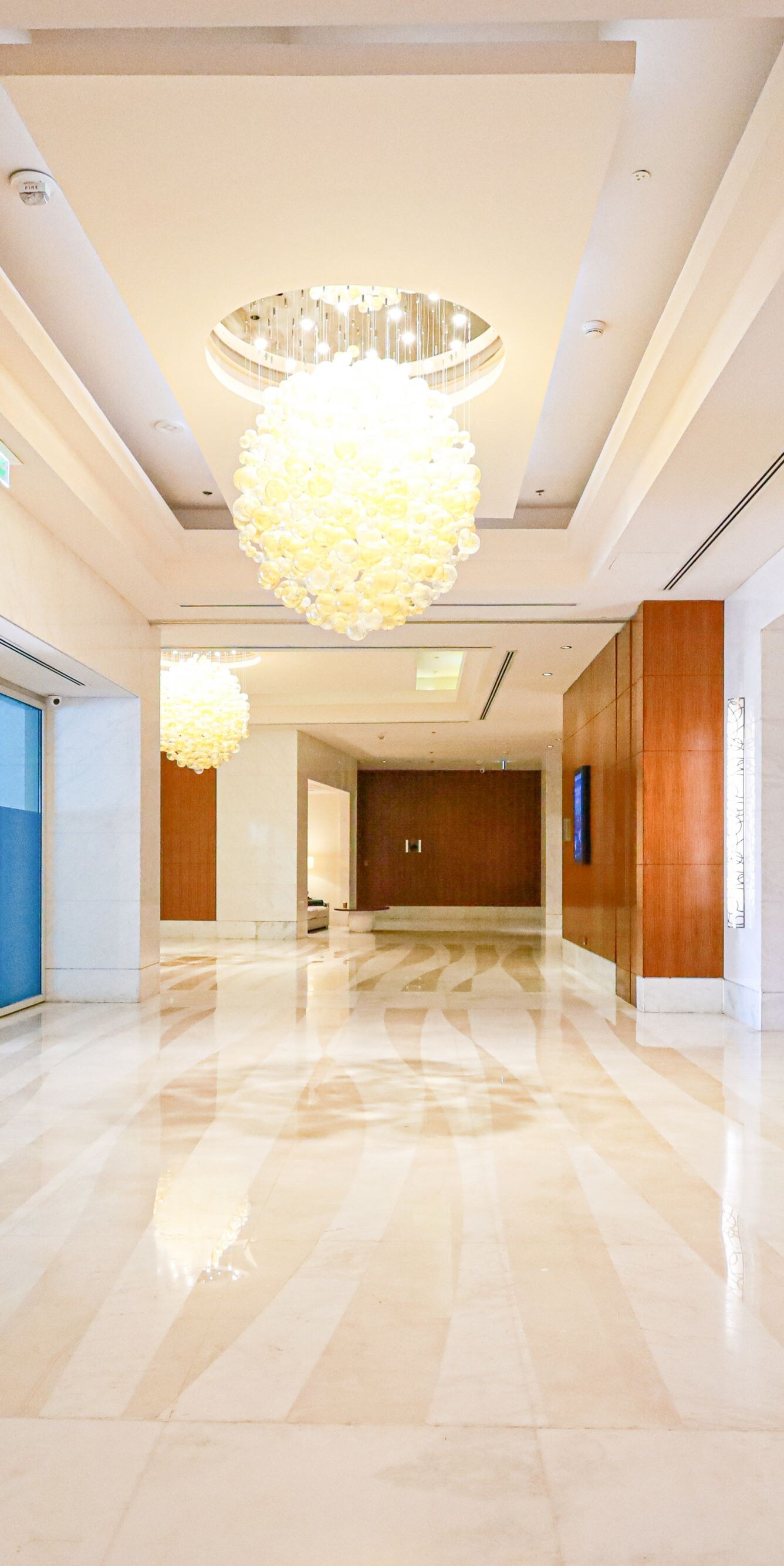 Hallway with marble floors and chandeliers