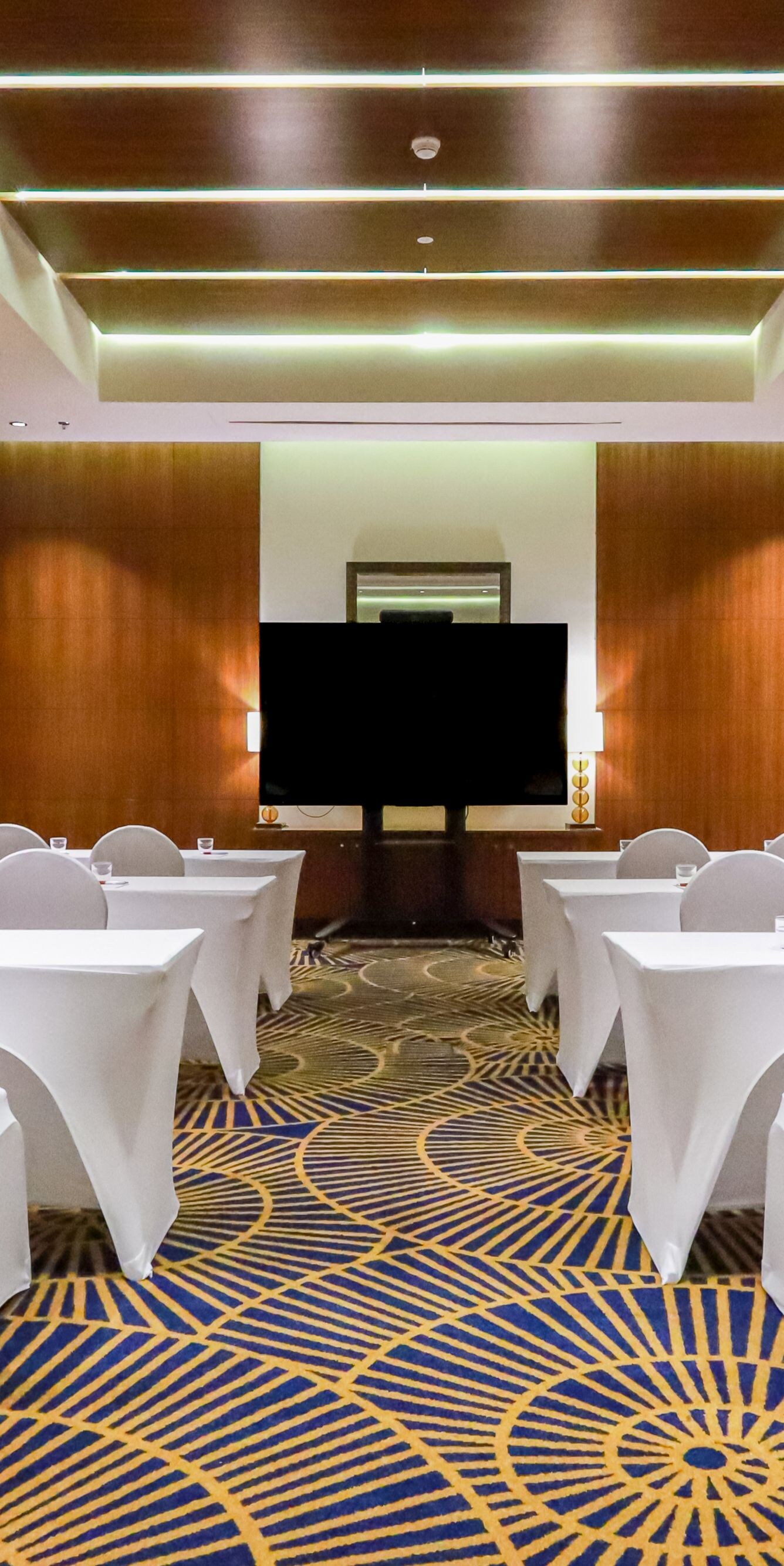 Sala riunioni ed eventi con allestimento a banchi di scuola e schermo