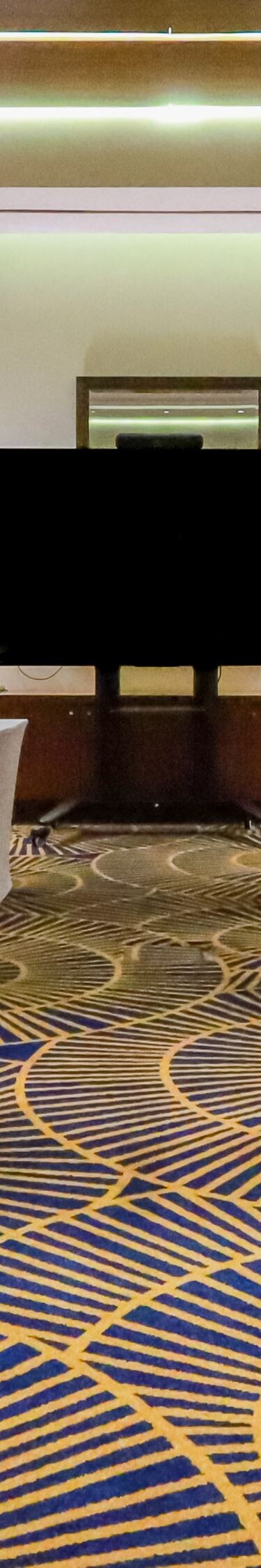 Sala riunioni ed eventi con allestimento a banchi di scuola e schermo