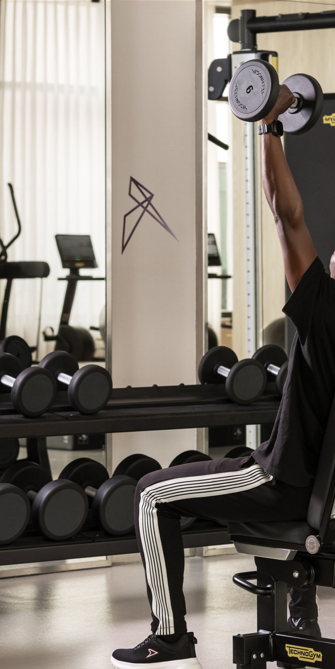 Fitness center with man lifting dumbbells