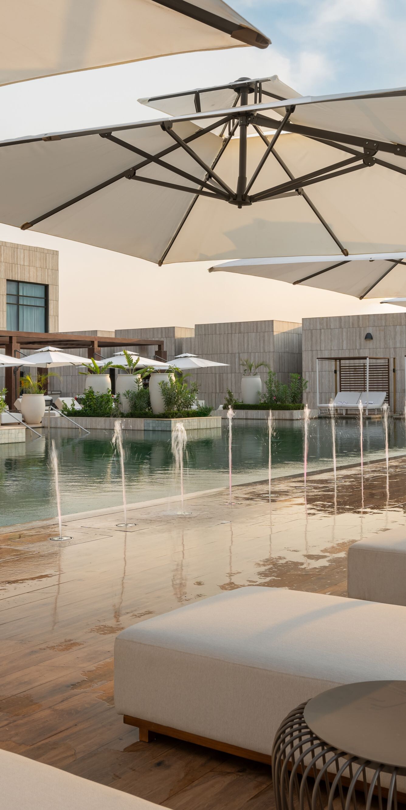 Outdoor pool with fountains and loungers