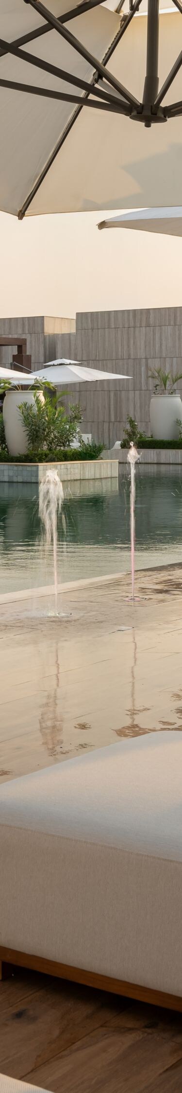 Outdoor pool with fountains and loungers