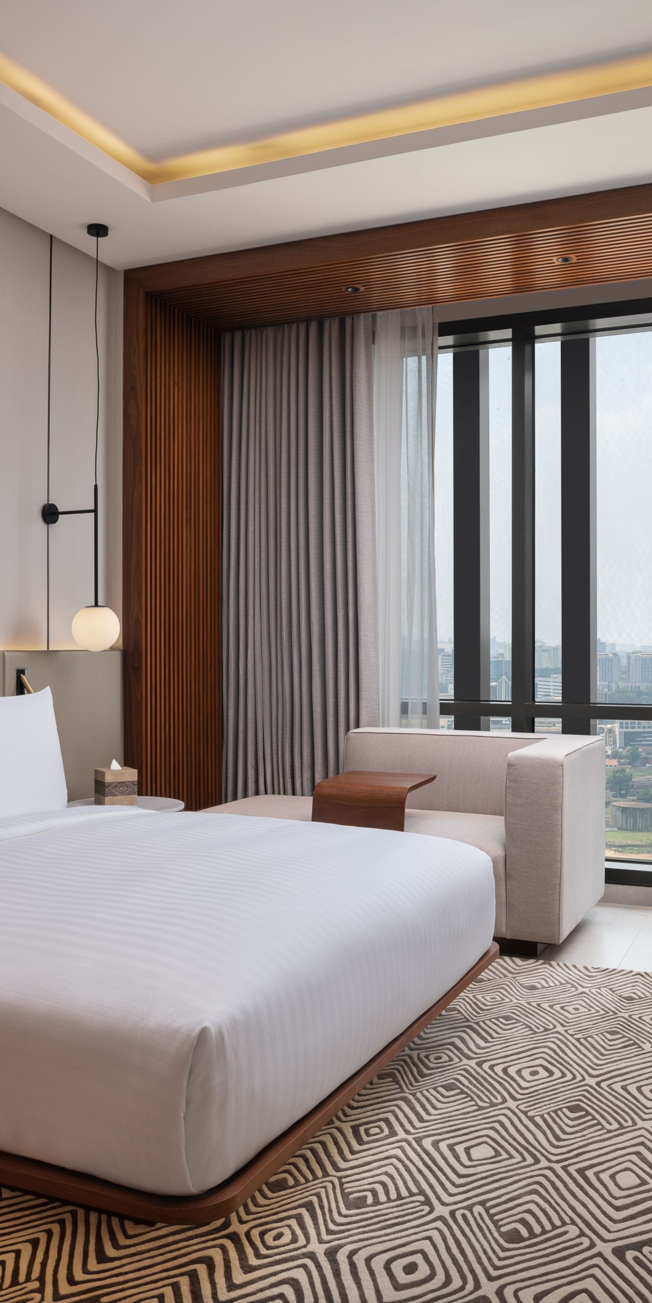 suite bedroom with city view and desk