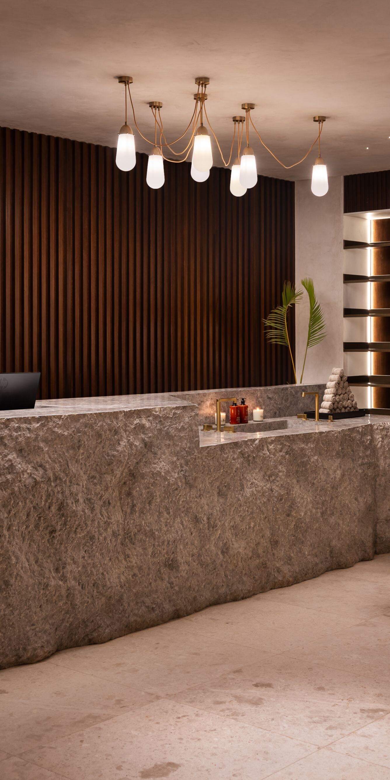 Spa reception with stone desk and shelving