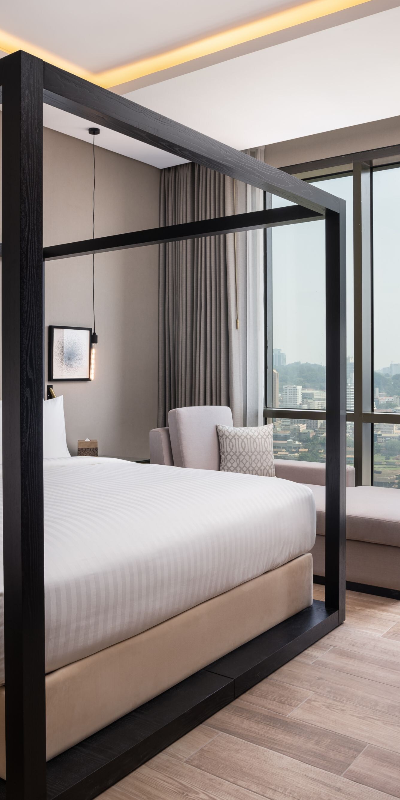 suite bedroom with canopy bed and city view