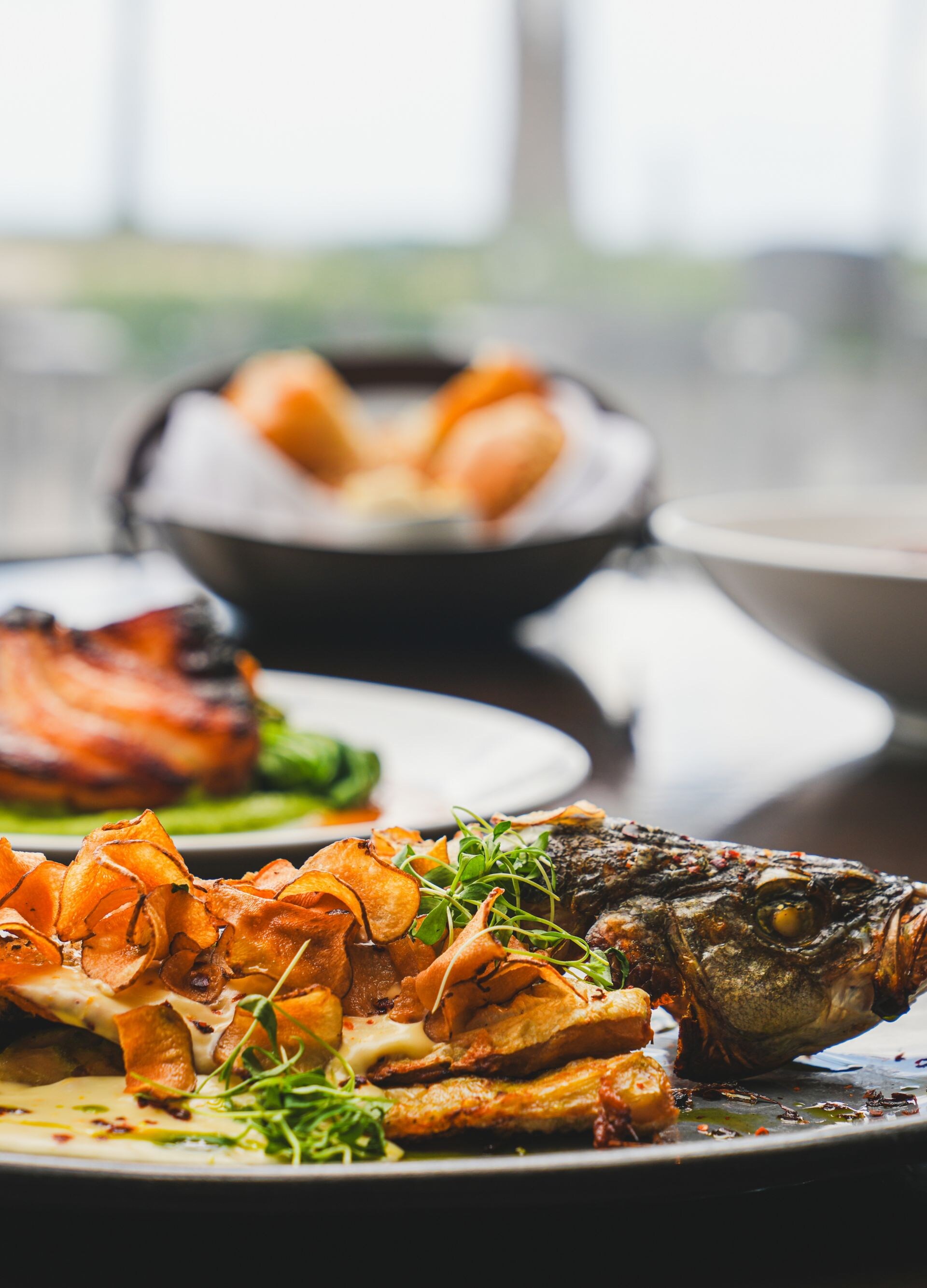 Plated whole fish with mushrooms and herbs by wine