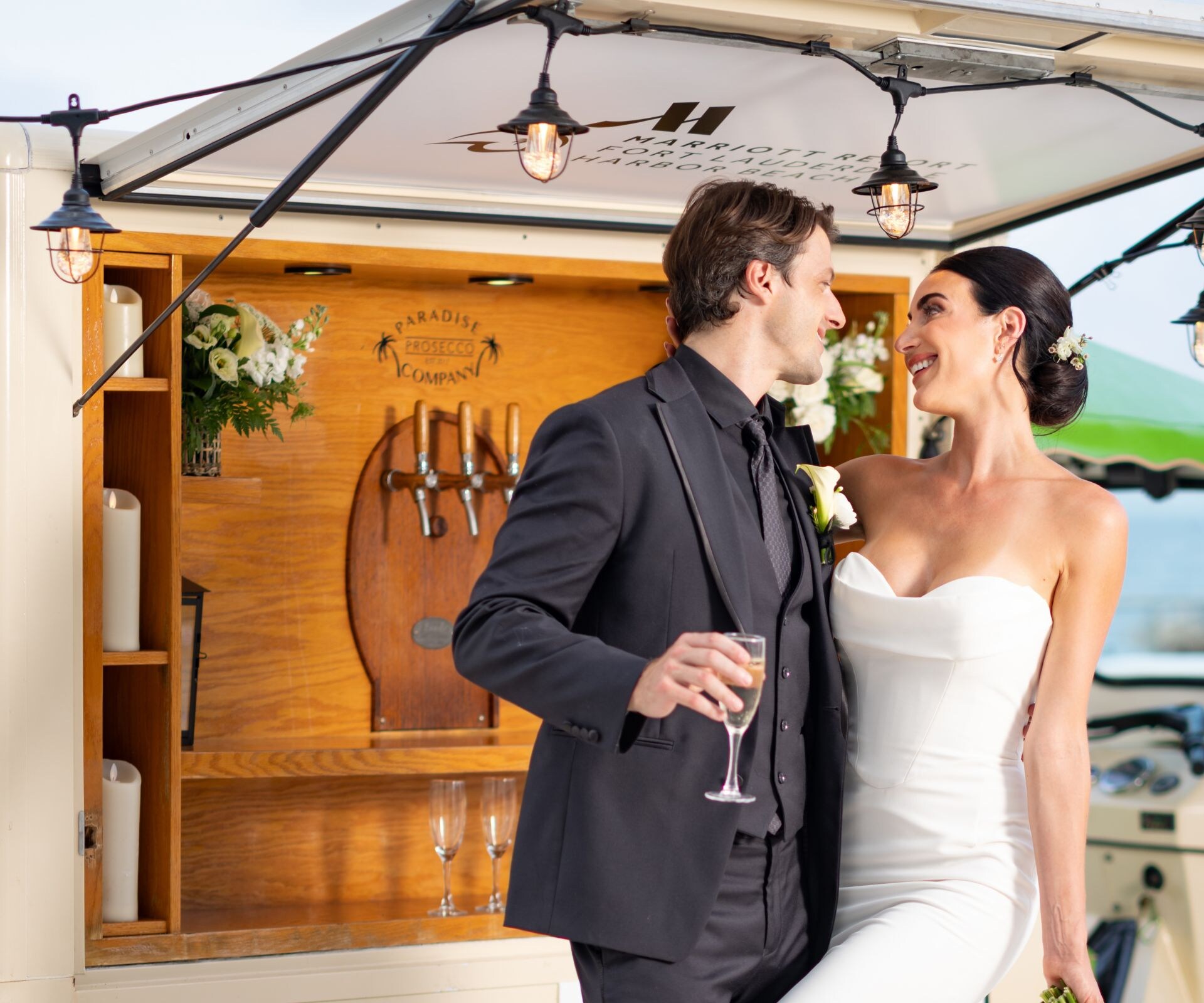 Couple standing beside beverage cart by the beach