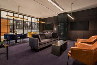 Espacio para reuniones con pantallas y mobiliario de lounge