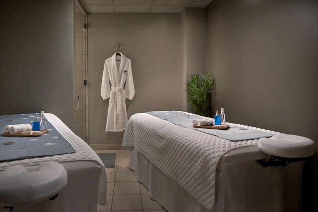 Spa treatment room with two massage tables.