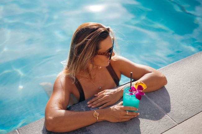 Woman in pool with a cocktail