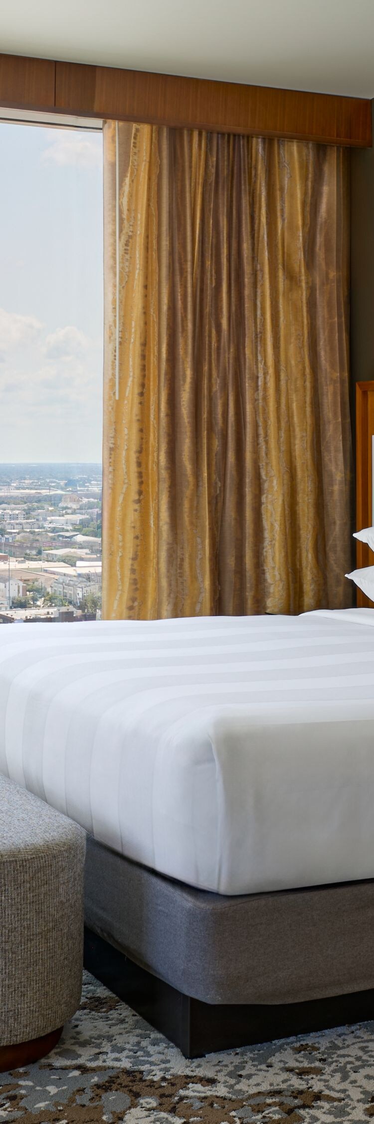Habitación con cama tamaño King, silla y vista a la ciudad