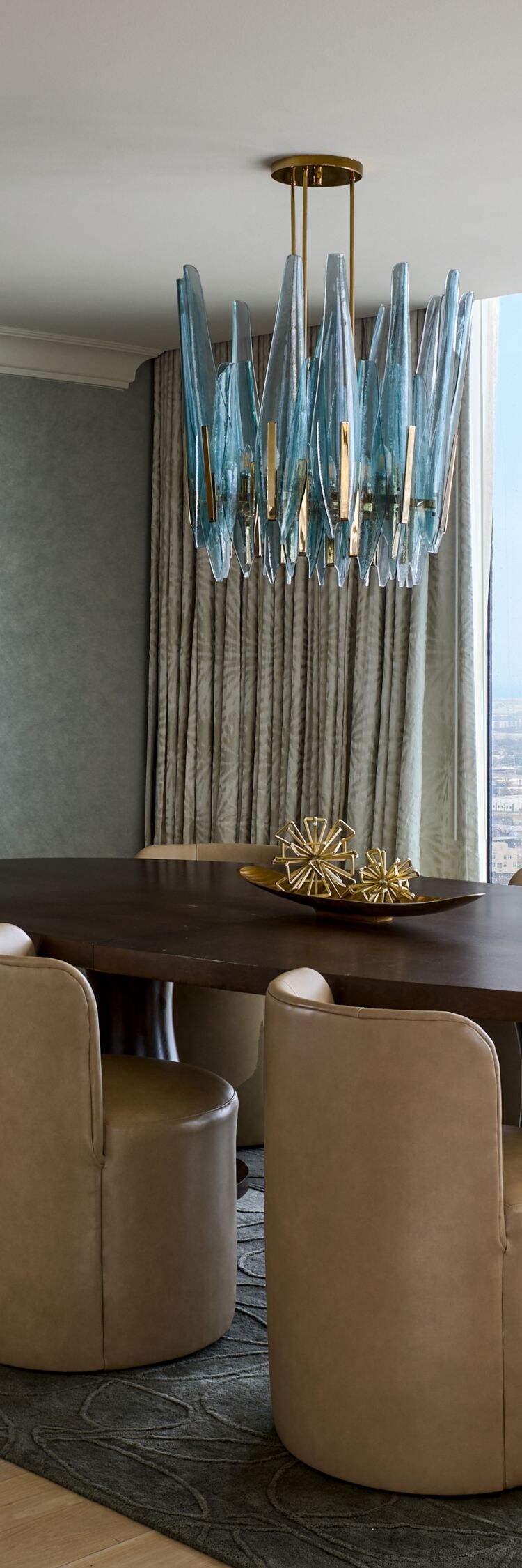 Mesa de comedor rodeada de sillas y vista a la ciudad