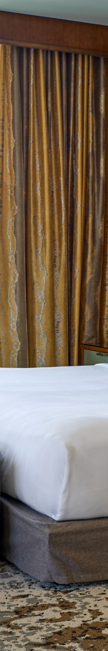 Cama tamaño King con banco y silla con vista a la ciudad
