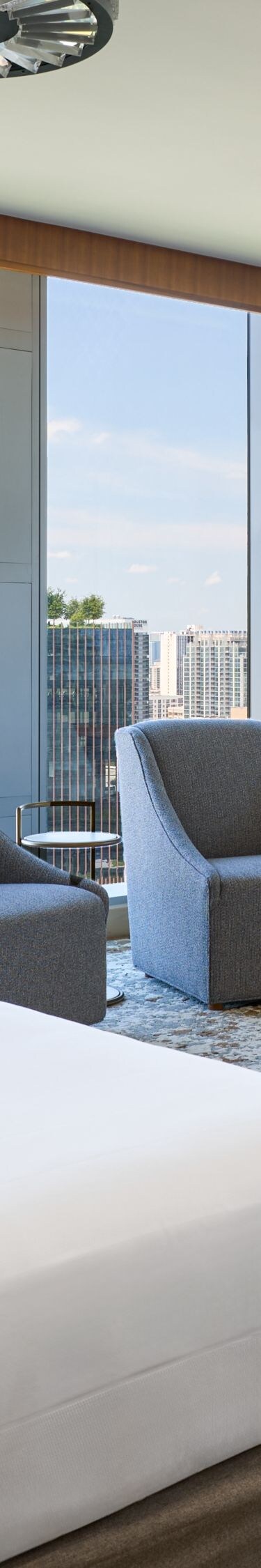 Cama tamaño King y comedor con vista a la ciudad