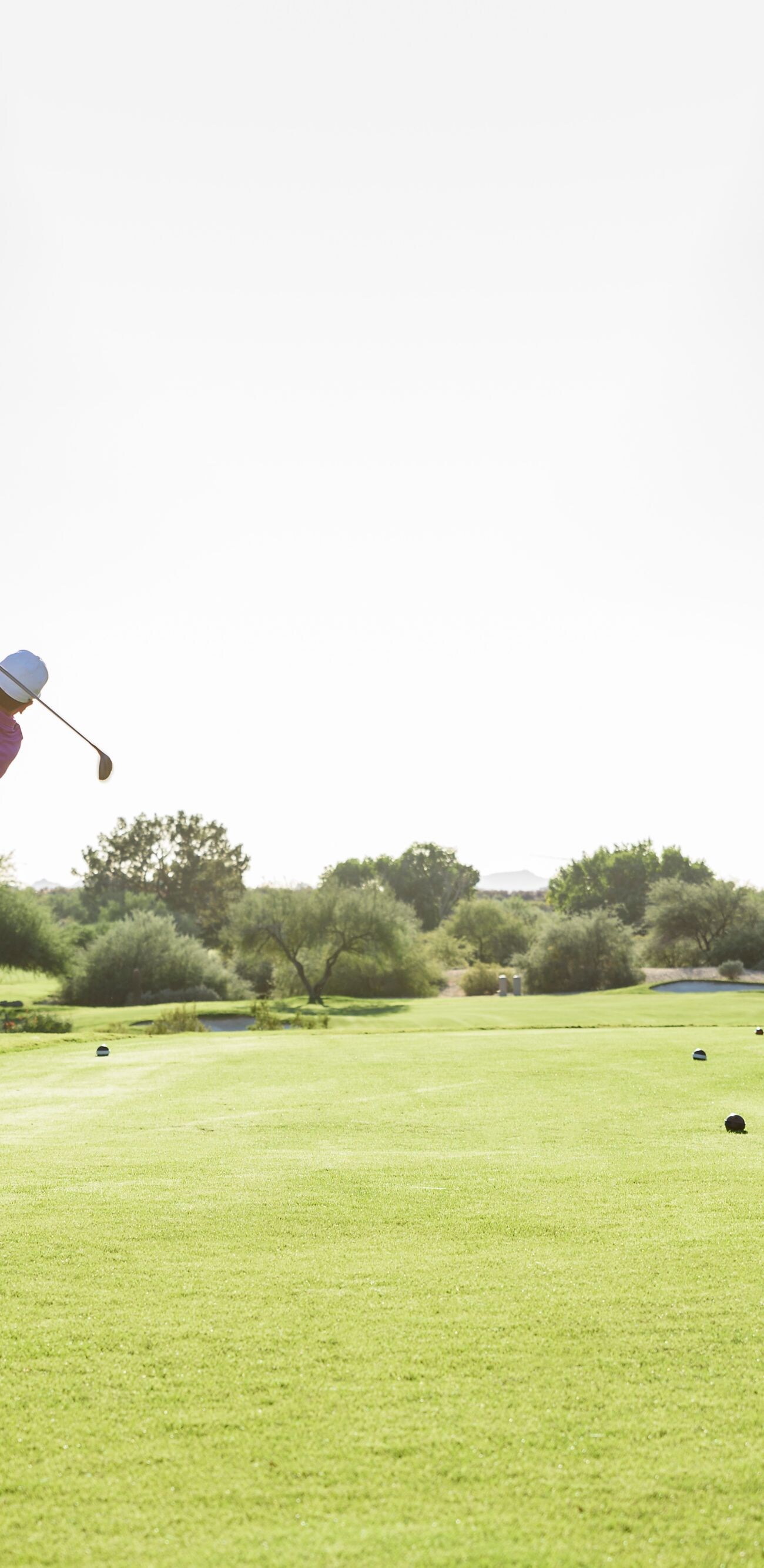 Golfer teeing off on a golf course