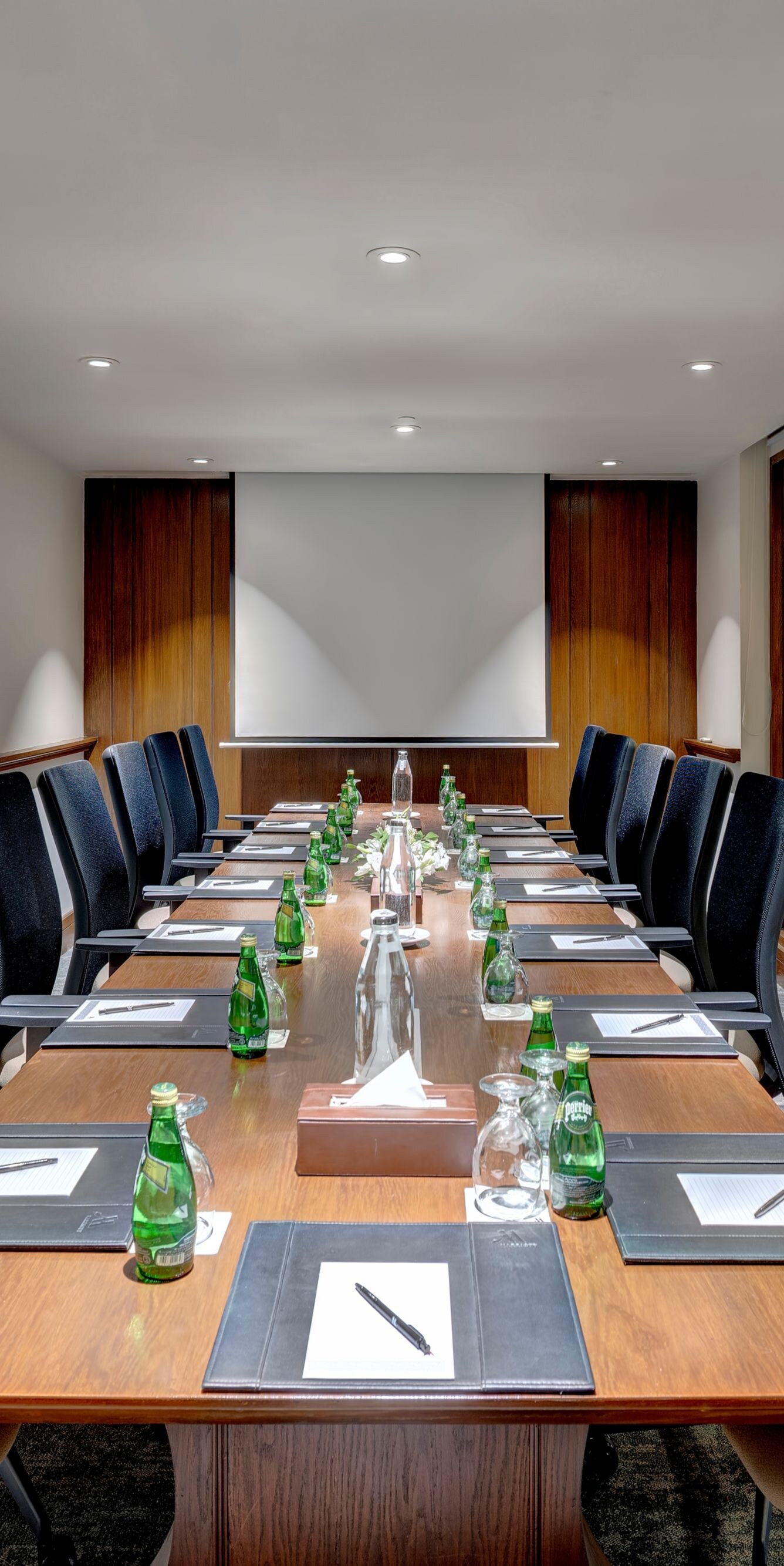Boardroom table with chairs and water bottles