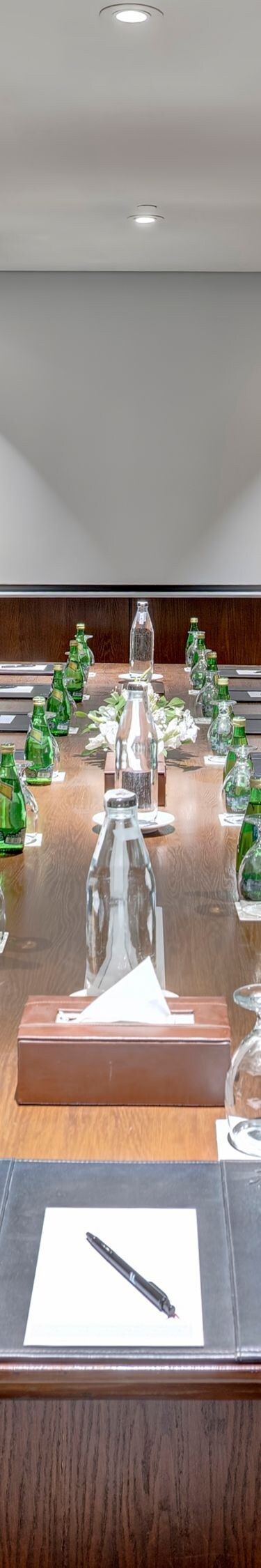 Boardroom table with chairs and water bottles
