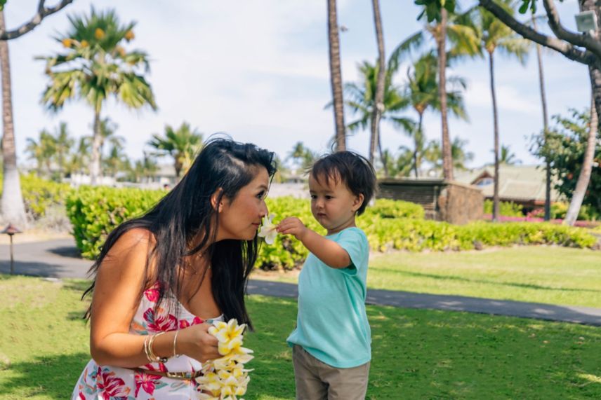 mom, son, smelling flowers, outside, palm trees