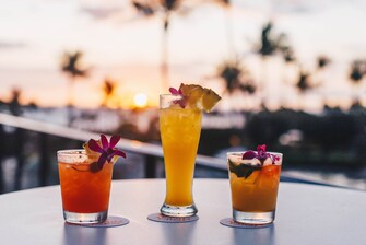 Three tropical and colorful drinks with garnishes