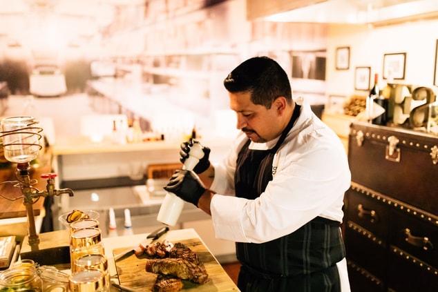 Picture of chef seasoning food in restaurant