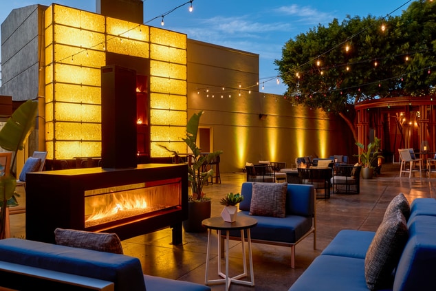 Outdoor patio with chairs, fire wall and fire pit