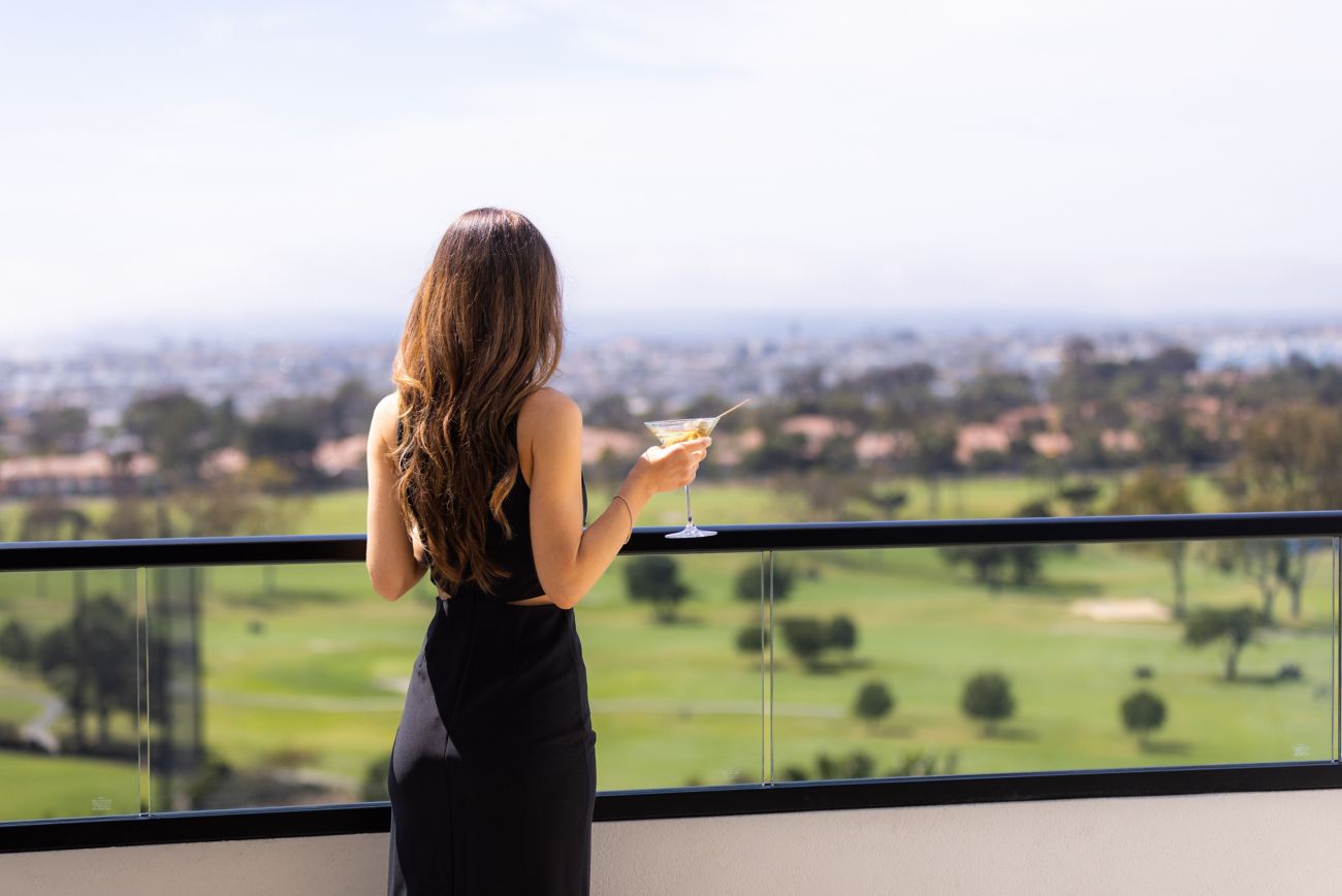 Woman on balcony looking at coastline view