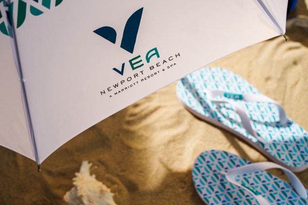VEA Umbrella and flip flops on the beach